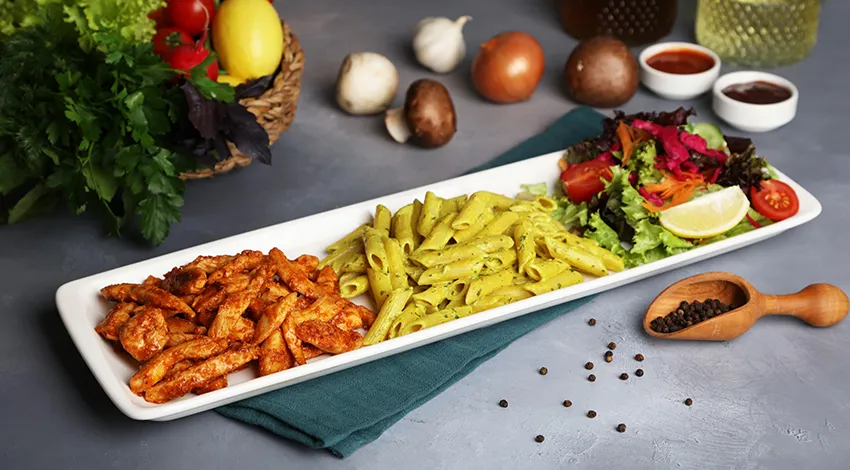 Uzun tabak içerisinde ızgara tavuk sote ve salata.