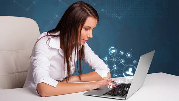 Genç bir kız laptop ile internette geziniyor